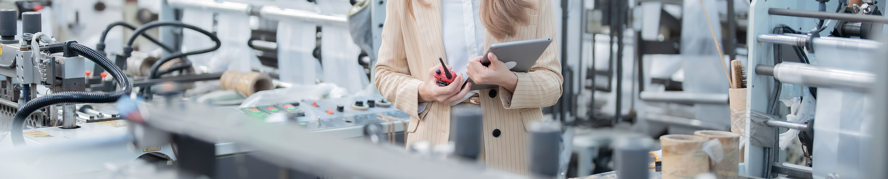 Filming A Documentary About Working In An Industrial Factory With Plastic Production Machinery And An Asian Female Engineer, Holding A Tablet, Radio, Wearing A Suit And Hard Hat, Being A Businesswoman